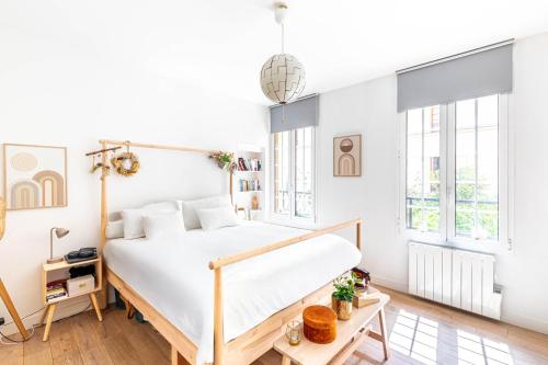 - une chambre avec un lit blanc et des fenêtres dans l'établissement GuestReady - Elegant retreat near the Eiffel Tower, à Paris