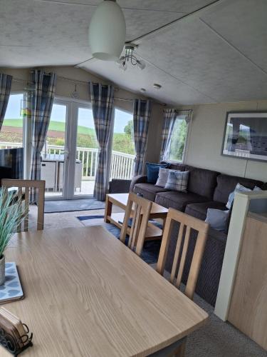 a living room with a table and a couch at Carnoustie 24 - Turnberry Holiday Park - short walk to beach in Girvan