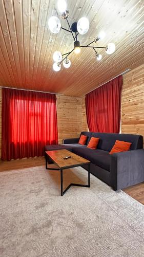 a living room with a blue couch and red curtains at Wood House 2 in Bosteri