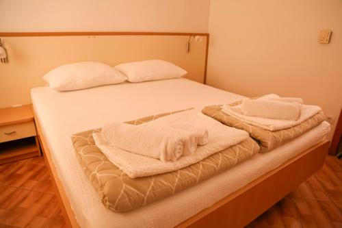 a bedroom with a bed with two towels on it at Villa Lasić Neum in Neum