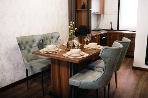 a dining room table with two chairs and a table with glasses at Apartmani Residence4sisters in Zvornik