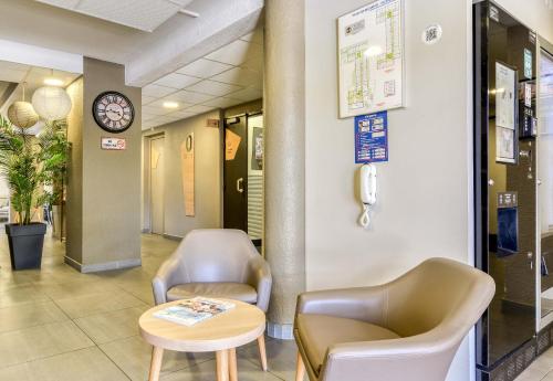 a waiting room with two chairs and a table at B&B HOTEL Narbonne 2 in Narbonne