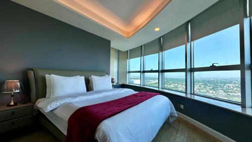 een slaapkamer met een groot bed en grote ramen bij Luxury 3-Bedroom Apartment at Centaurus City View in Islamabad