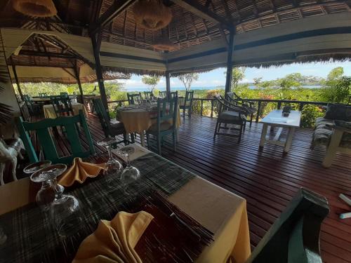 a restaurant with a table and chairs on a deck at La Table d Alexandre Gîte de charme entre mangrove et mer in Hell-Ville