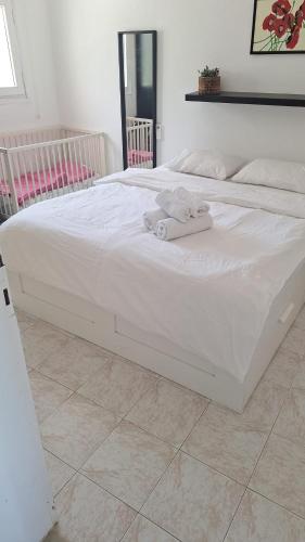 a white bed with towels on it in a bedroom at Bougainvilla Ground floor in Çeşme
