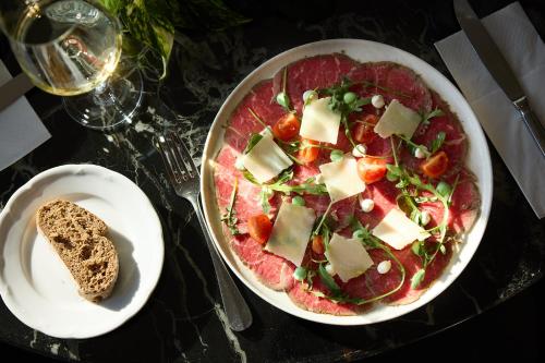 a table with a pizza and a plate of bread at President Hotel Athens in Athens