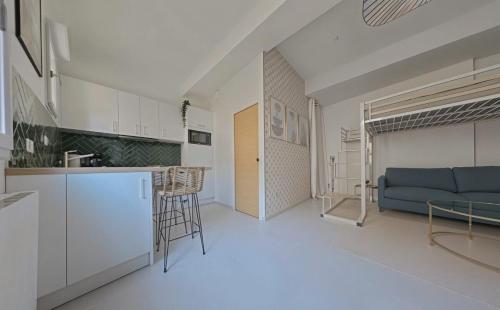 Il comprend une cuisine et un salon avec un canapé bleu. dans l'établissement Charmant studio contemporain, à Montpellier
