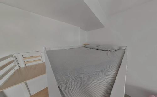 une chambre avec un lit dans une pièce blanche dans l'établissement Charmant studio contemporain, à Montpellier