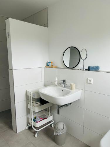 a white bathroom with a sink and a mirror at Deluxe in Burladingen