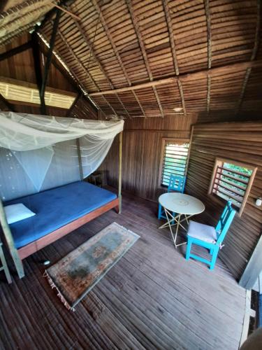 an overhead view of a room with a bed and a table at La Table d Alexandre Gîte de charme entre mangrove et mer in Hell-Ville