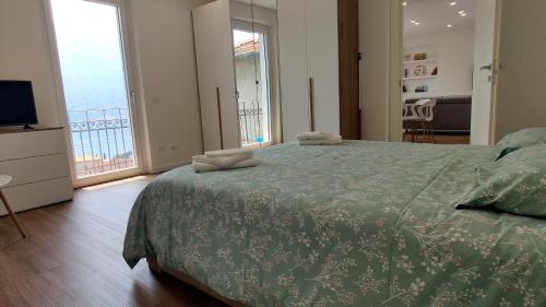 a bedroom with a bed with a green comforter at Vista Lago Como in Ossuccio