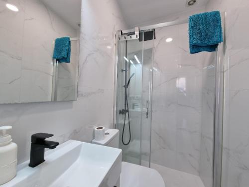 a white bathroom with a shower and a sink at VibesCoruna-Meloxo 59 in Melojo