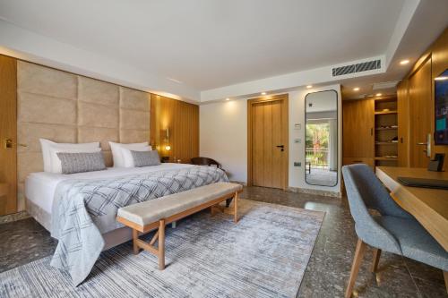 a hotel room with a bed and a table and chairs at Mövenpick Resort Antalya Tekirova - Ultra All Inclusive in Tekirova