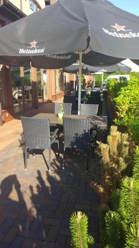 a table and chairs under an umbrella on a patio at Hotel SenS in Mierzyn