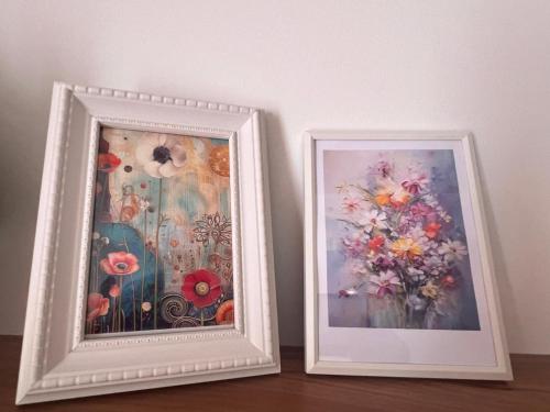 two framed pictures of flowers on a wall at Family Haven Serin West Tagaytay - 6 Pax - Taal View - Full Kitchen - FAST Wi-Fi in Tagaytay