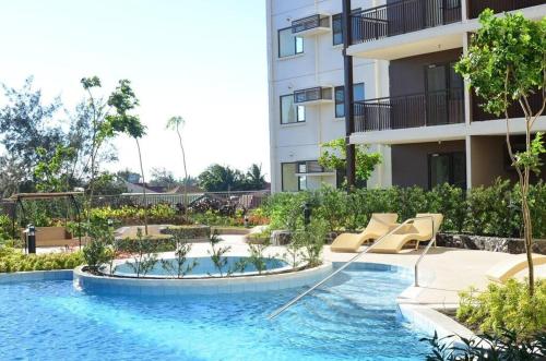 大雅台Family Haven Tagaytay - 6 Pax - Taal View - Full Kitchen - FAST Wi-Fi SERIN WEST CONDO的建筑物前的游泳池