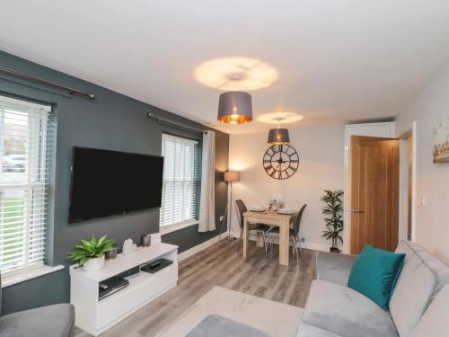 a living room with a couch and a tv at Rosie's Retreat, The Bay, Filey in Filey