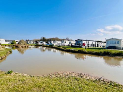 un río con casas en el fondo en Etna Laurels at the peaceful Cherry Lea Holiday Park and Fishing Lake, en Burgh le Marsh