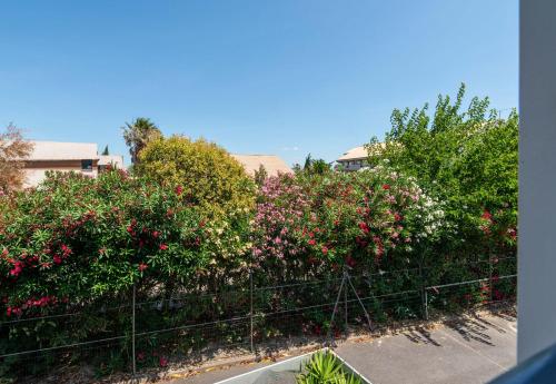 a row of bushes with red and white flowers at B&B HOTEL Narbonne 1 in Narbonne