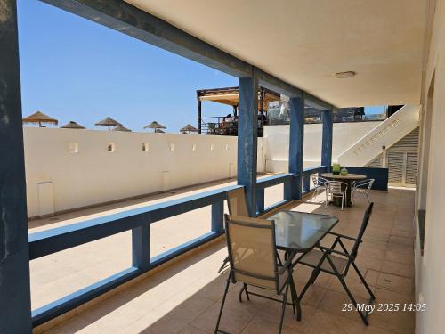 a balcony with chairs and a table with a view at Blife Bandaya private rooms at Faro beach in Faro