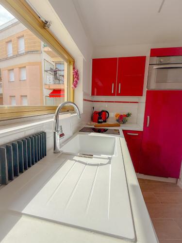 - une cuisine avec un évier blanc et des placards rouges dans l'établissement Le Santa By ApiRent #Climatisation #Plage #Vue mer, à Cannes