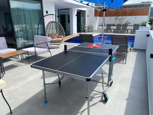 a ping pong table with chairs and an umbrella at VillA Ari in Kas