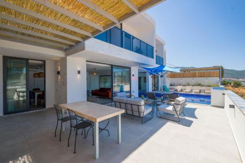 a house with a table and chairs on a patio at VillA Ari in Kas