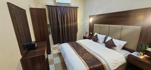 a bedroom with a large bed with a wooden headboard at العييري للشقق المخدومة الباحة 4 in Al Baha