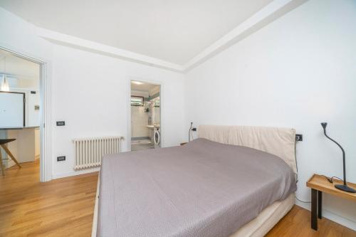 ein weißes Schlafzimmer mit einem Bett und einem Tisch in der Unterkunft Lady Suite in Udine