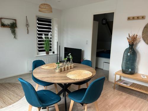 une salle à manger avec une table en bois et des chaises bleues dans l'établissement SB Bed and Breakfast Contemporain, à Charleville-Mézières