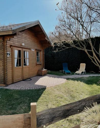 a house with a patio and two chairs in the yard at TinyHouse Meereszauber- ruhige Lage, eigener Garten, Grill in Wolgast
