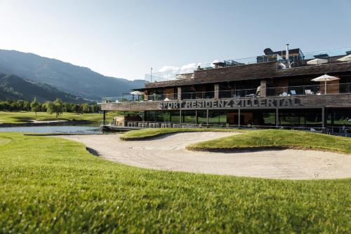 a golf course with a hotel in the background at Sportresidenz Zillertal - 4 Sterne Superior in Uderns