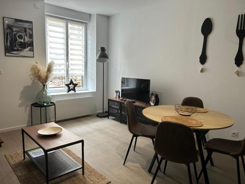 un salon avec une table, des chaises et une télévision dans l'établissement SB Bed and Breakfast Industriel, à Charleville-Mézières