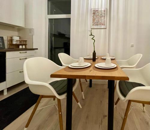 a dining room table and chairs in a kitchen at Elster 1, EG, Neues Apartment in Gera, 4 Schlafzimmer, 2 WCs und Bad sowie Terrasse in Gera