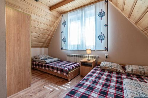 a bedroom with two beds and a window in a room at Willa Tatra House in Zakopane