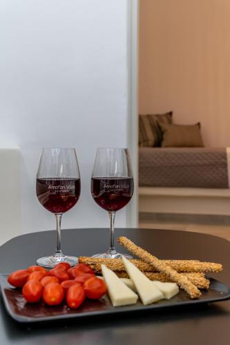 two glasses of wine and cheese on a table at AnnaFani Villa in Pirgos
