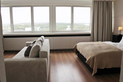 a bedroom with a bed and a couch and windows at Apartment In SI-Centrum in Stuttgart