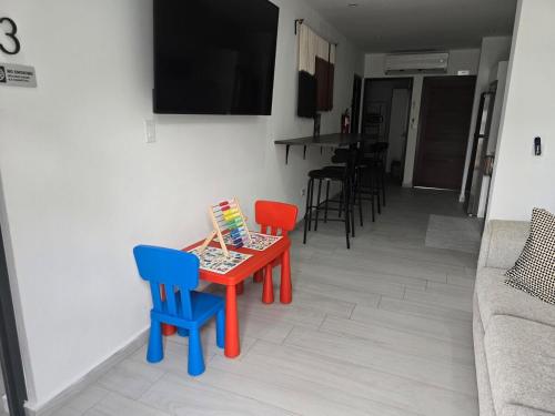 a small table with two chairs and a tv in a living room at Renovated 3 BR House in Dorado del Mar in Dorado