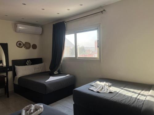 a bedroom with two beds and a window at Isis pyramids in Giza