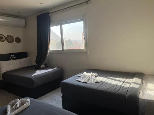 a room with two beds and a window at Isis pyramids in Giza