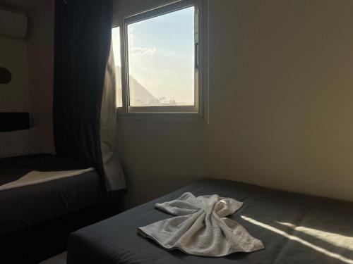 a towel on a bed in a room with a window at Isis pyramids in Giza