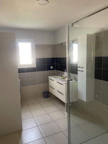 une salle de bain avec douche et lavabo dans l'établissement Villa calme deux chambres proche de la mer tout confort, à Pinet