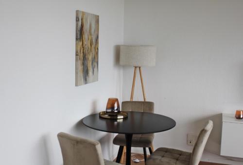 a dining room table with chairs and a lamp at Apartment In SI-Centrum in Stuttgart