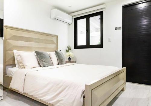 a bedroom with a large bed and a window at Renovated 3 BR House in Dorado del Mar in Dorado