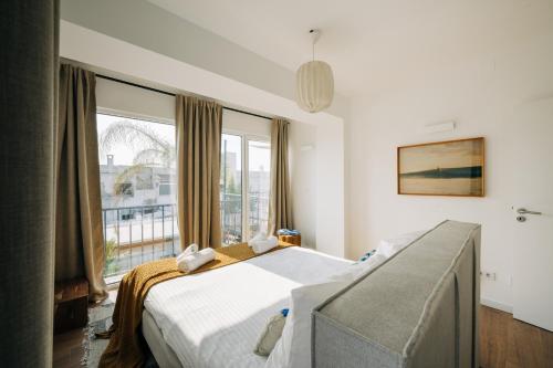 ein Schlafzimmer mit einem Bett und einem großen Fenster in der Unterkunft Octopus House Caparica in Costa da Caparica