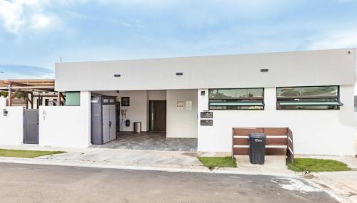 a white building with a bench in front of it at Renovated 3 BR House in Dorado del Mar in Dorado