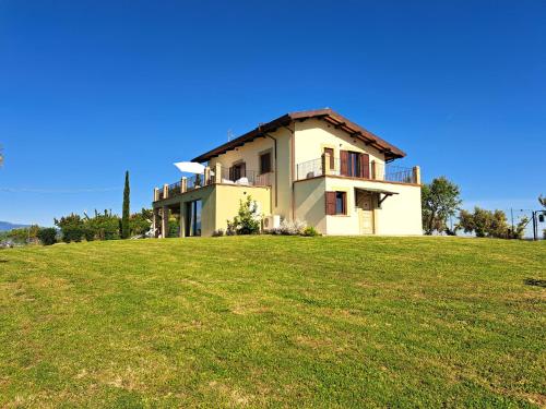 a house on top of a grassy hill at Characteristic restored farmhouse with 360 degree views in Montefino