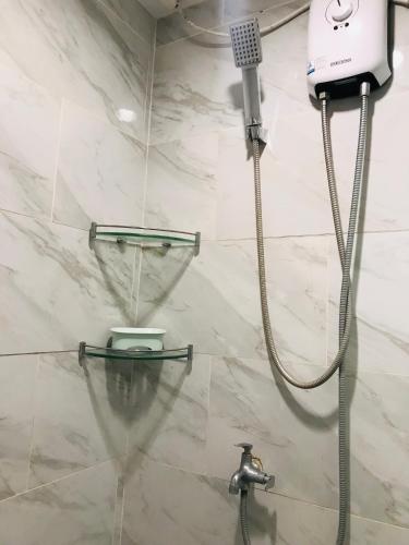 a shower in a bathroom with a shower head at Cityscape Grand Tower Condo, studio unit in Cebu City