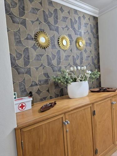 a wooden cabinet with two mirrors on a wall at Oceano Azul in Porto Santo