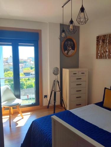 a bedroom with a bed and a dresser and a camera at Fridda House Rias Baixas Vigo in Cangas de Morrazo